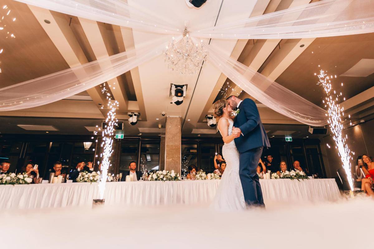 Bride and Groom on dancefloor with fireworks kissing